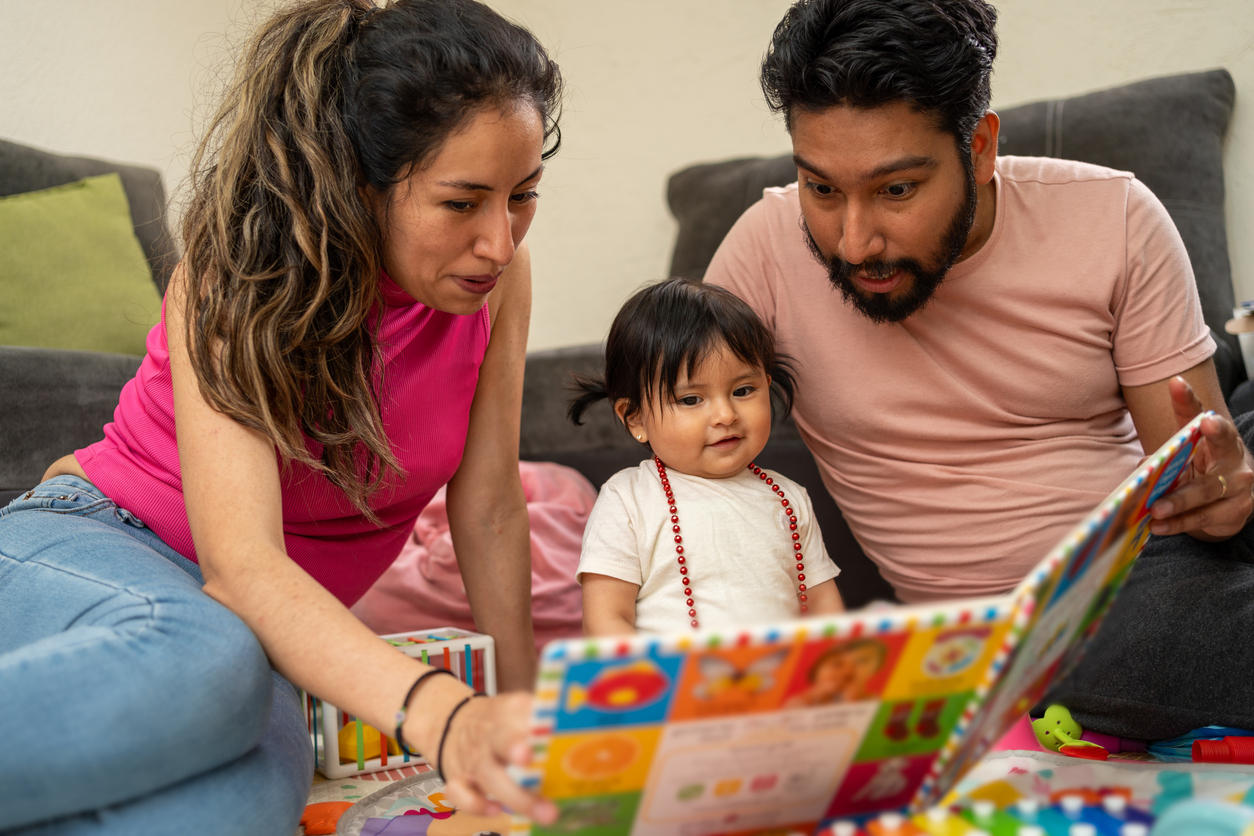 Hispanic Family Reading a Learning Book to Their Baby Daughter, Young Latin Couple Enjoying Time with Their Toddler